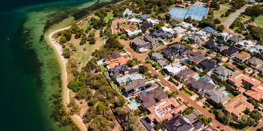 aerial view showing coastline, rooftops, backyards, roads and surrounding area